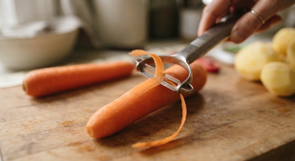 OXO Good Grips Pro Y-peeler peeling a carrot on a wooden board